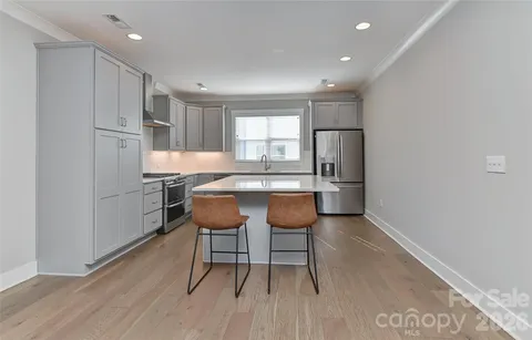 a kitchen with stainless steel appliances granite countertop a sink and a refrigerator