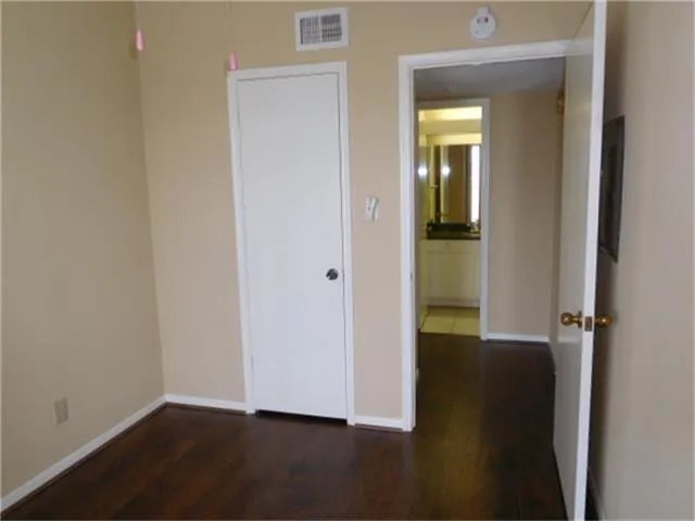 an empty room with wooden floor and closet