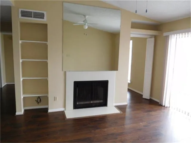 a view of a livingroom with wooden floor and a fireplace
