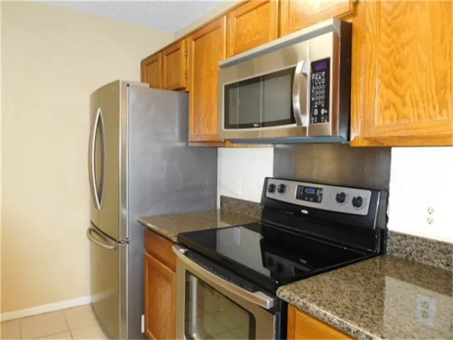 a kitchen with stainless steel appliances granite countertop a refrigerator and a stove