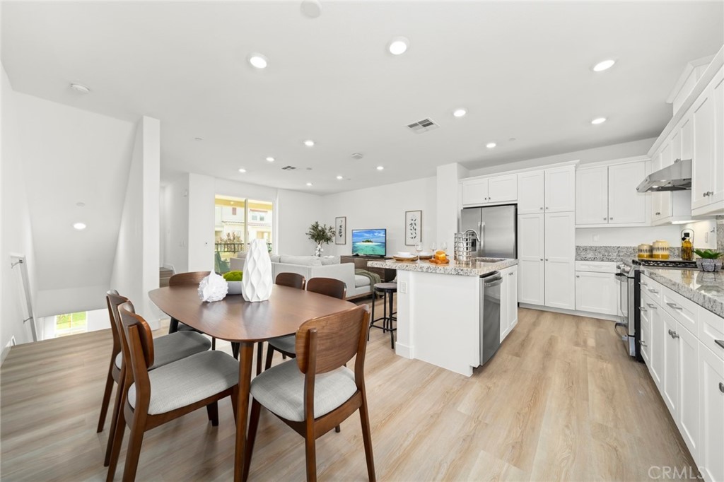 1533 St Simon Circle, Unit B Alhambra, CA 91803 - Photo 10 of 27 a kitchen with a dining table chairs and white appliances