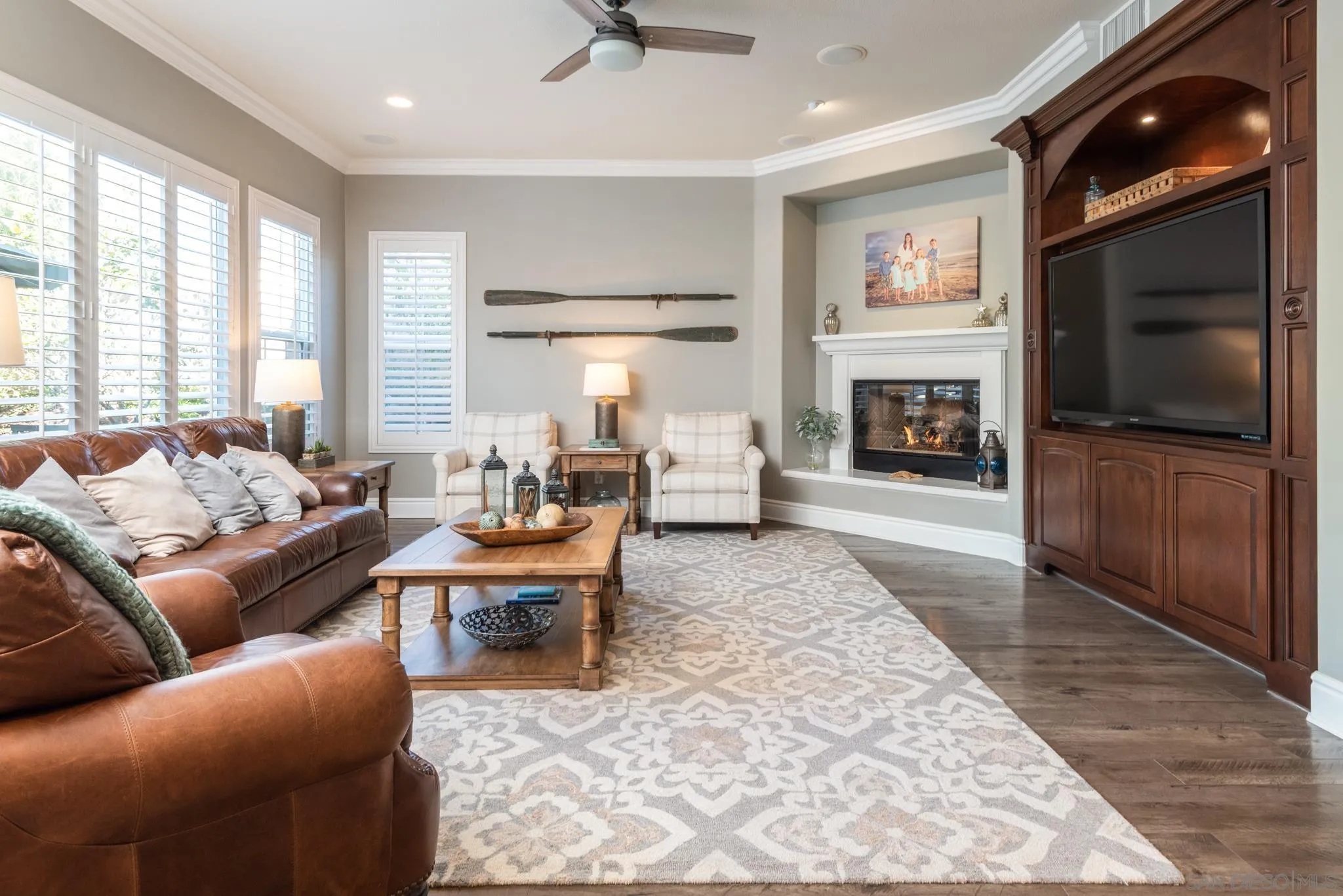 3234 Corte Aliso Carlsbad, CA 92009 - Photo 2 of 44 a living room with furniture a flat screen tv and a fireplace