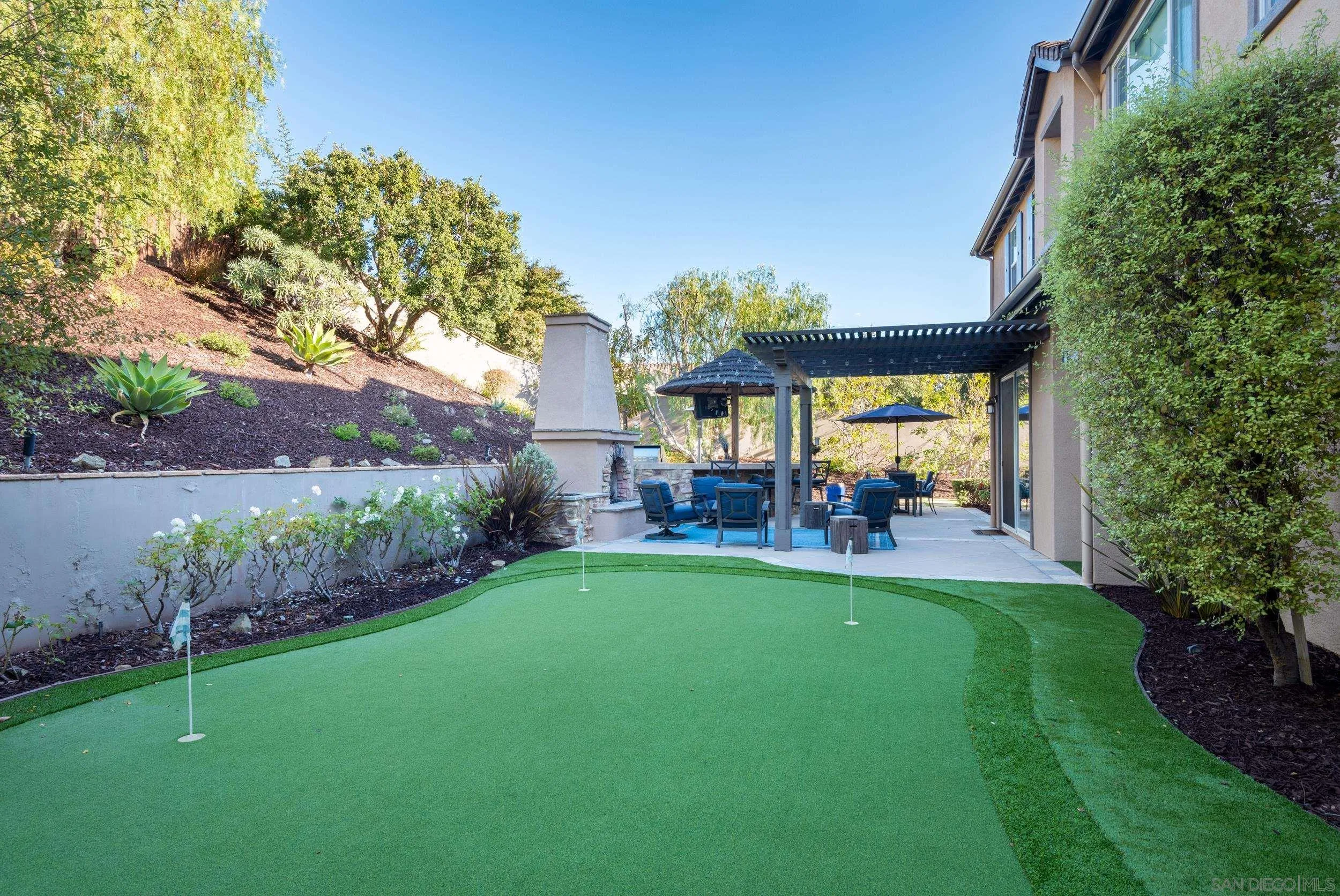 3234 Corte Aliso Carlsbad, CA 92009 - Photo 28 of 44 a view of a patio with table and chairs potted plants and large tree