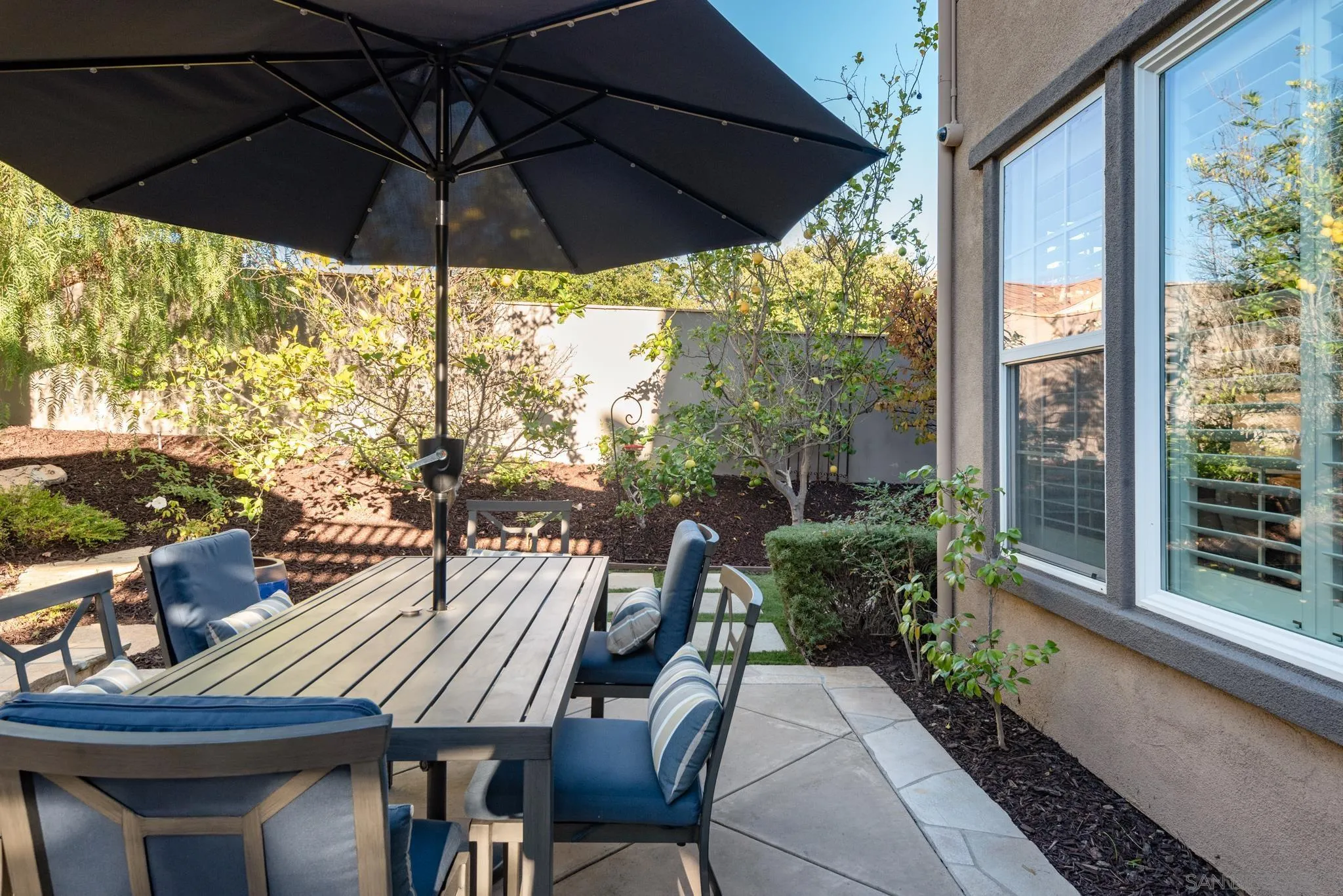 3234 Corte Aliso Carlsbad, CA 92009 - Photo 34 of 44 a view of a patio with table and chairs under an umbrella