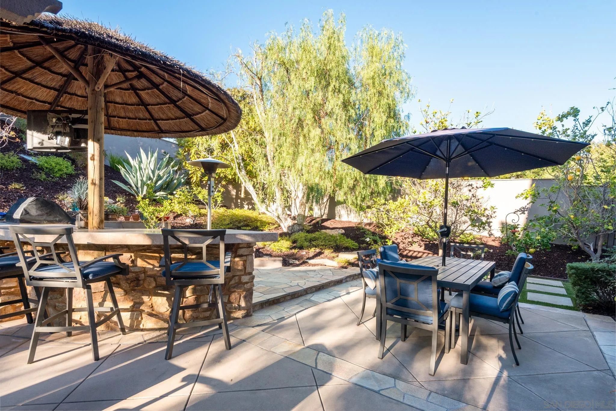 3234 Corte Aliso Carlsbad, CA 92009 - Photo 36 of 44 a view of patio with chairs and table under an umbrella with a barbeque