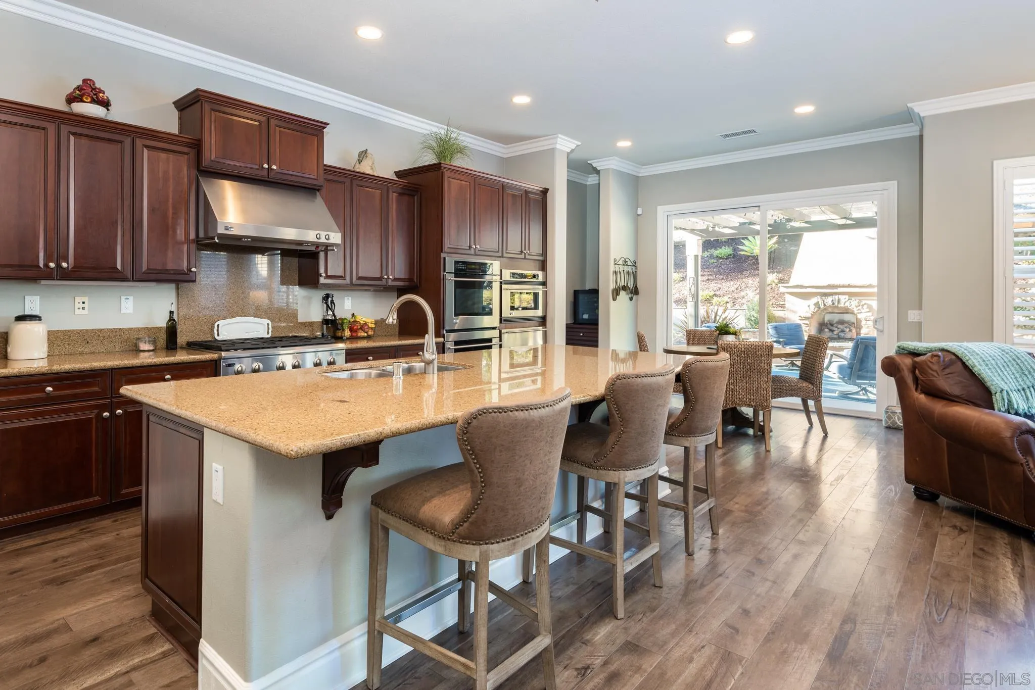 3234 Corte Aliso Carlsbad, CA 92009 - Photo 4 of 44 a kitchen with stainless steel appliances granite countertop a table chairs stove a sink dishwasher and cabinets with wooden floor