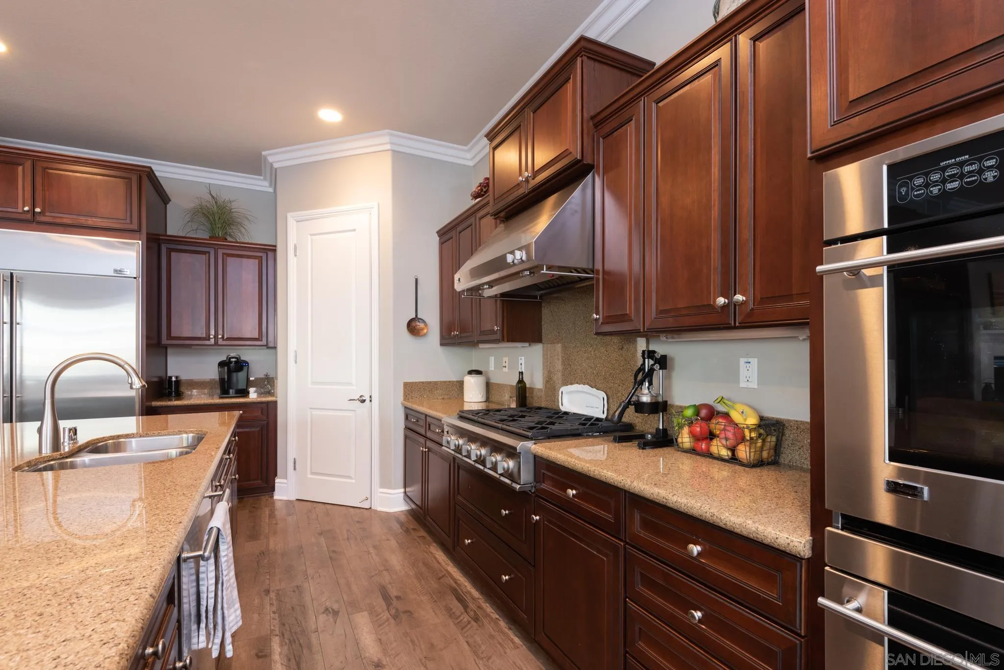 3234 Corte Aliso Carlsbad, CA 92009 - Photo 7 of 44 a kitchen with stainless steel appliances a sink a stove a refrigerator cabinets and a dining table