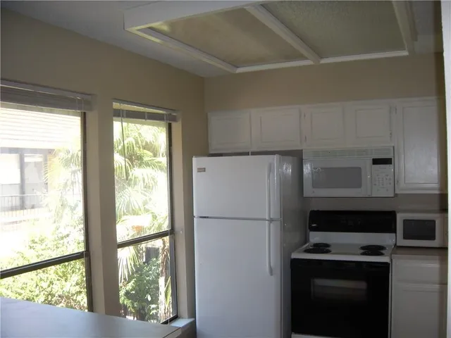 a white refrigerator freezer and a stove sitting inside of a kitchen