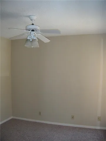 an empty room with a fan and a window