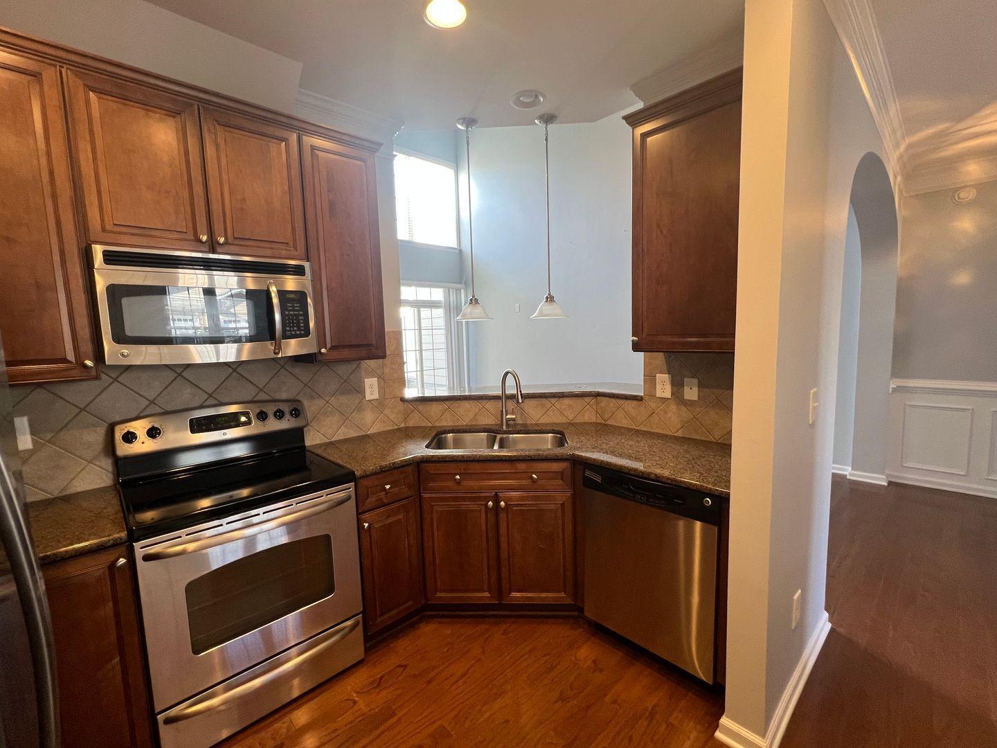 10117 Falls Meadow Court Raleigh, NC 27617 - Photo 14 of 34 a kitchen with a sink stove and microwave
