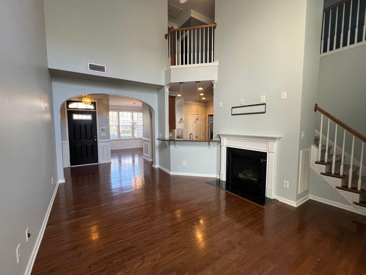 10117 Falls Meadow Court Raleigh, NC 27617 - Photo 15 of 34 a view of a hallway with wooden floor and a fireplace