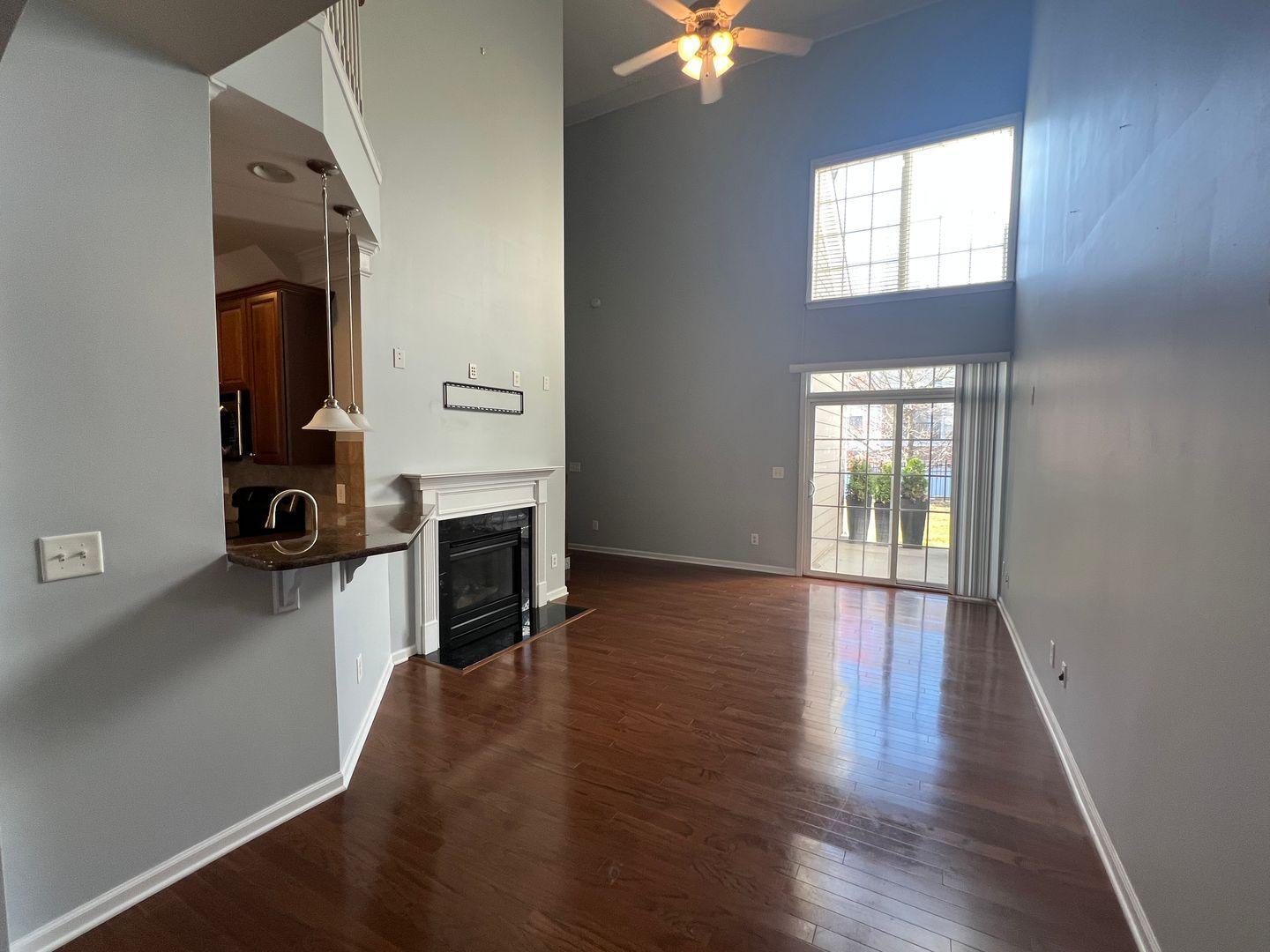 10117 Falls Meadow Court Raleigh, NC 27617 - Photo 23 of 34 an empty room with windows fireplace and wooden floor