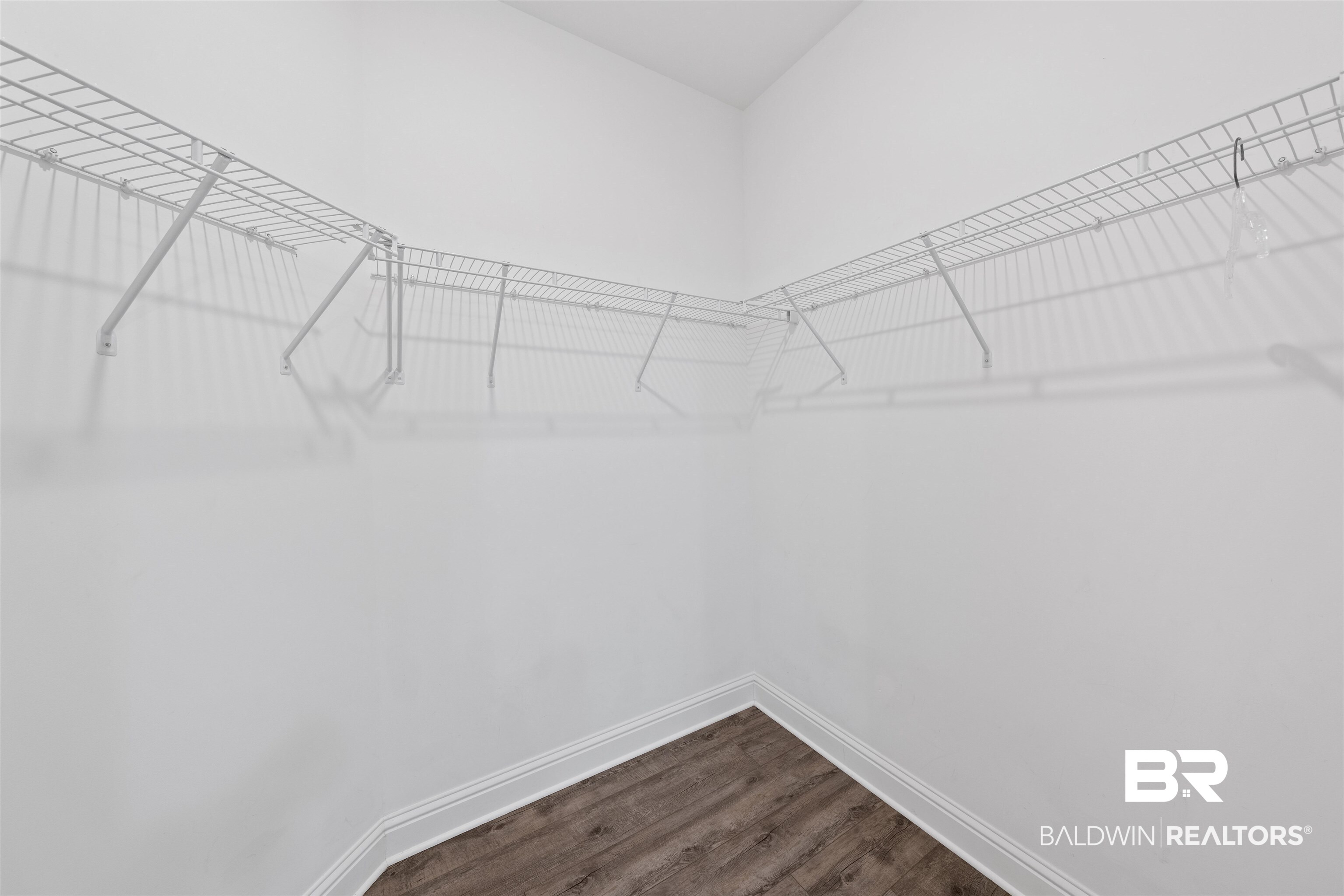 2651 South Juniper Street, Unit 1801 Foley, AL 36535 - Photo 14 of 16 Walk-in closet featuring white wire shelving, white wall paint, white trim, and wood-finish flooring