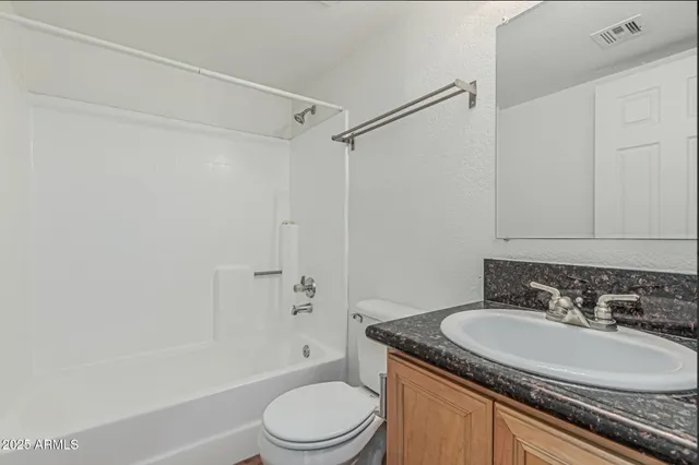 a bathroom with a granite countertop sink toilet a mirror and shower