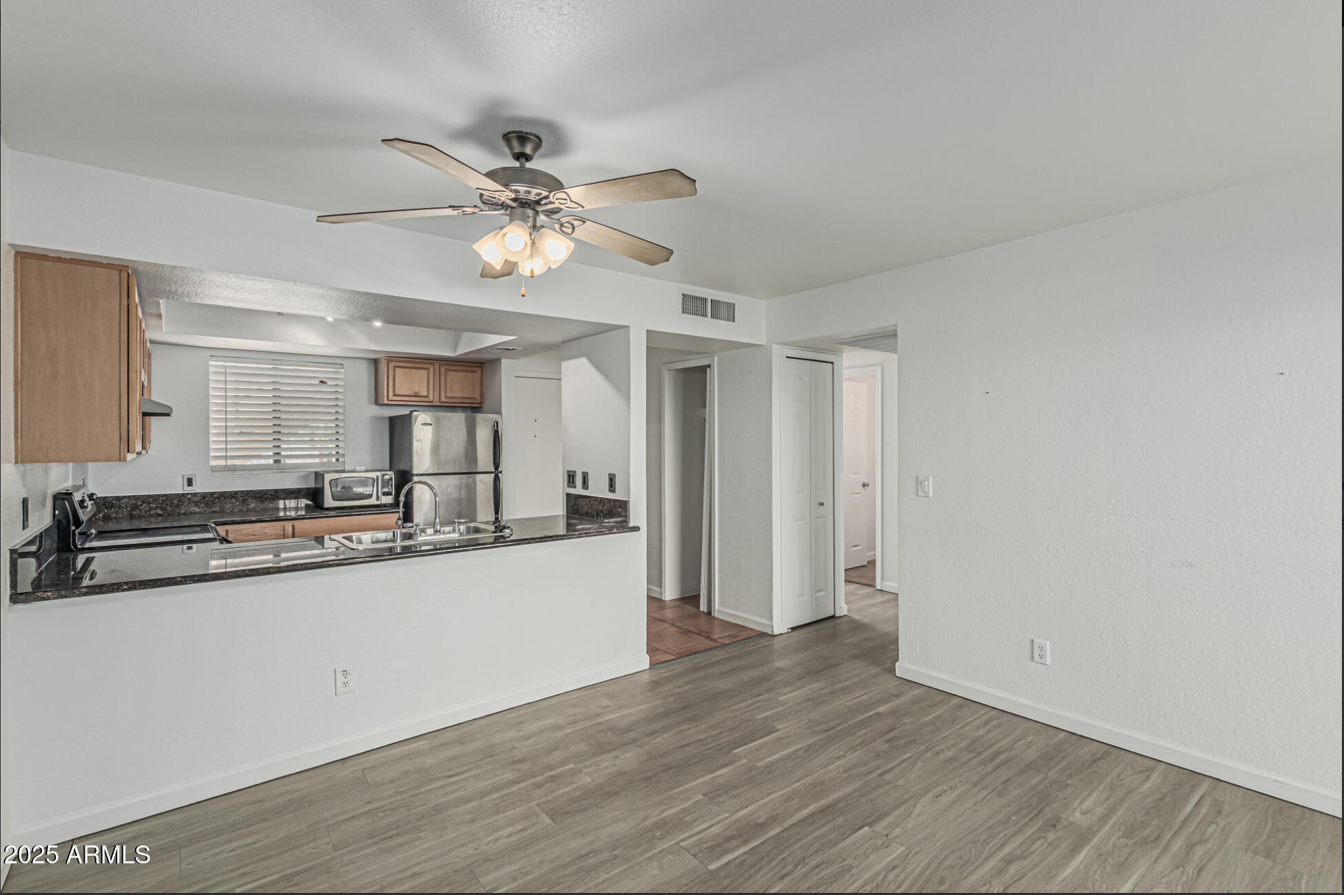 1065 West 1st Street, Unit 102 Tempe, AZ 85281 - Photo 6 of 24 a large white kitchen with wooden floor and a ceiling fan