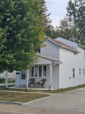 a view of a white house with large windows and a large tree