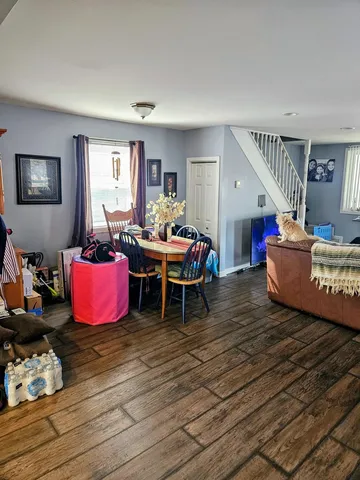 a living room with furniture a wooden floor and next to a window