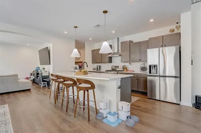 a kitchen with stainless steel appliances granite countertop a table chairs sink and stove top oven