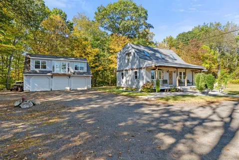 a view of a house with a yard and large tree