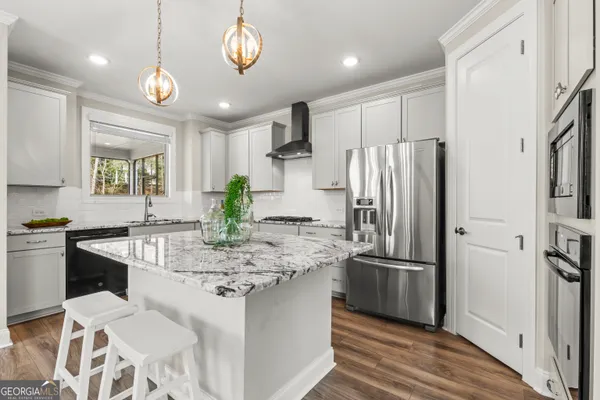 a kitchen with stainless steel appliances granite countertop a sink refrigerator and cabinets