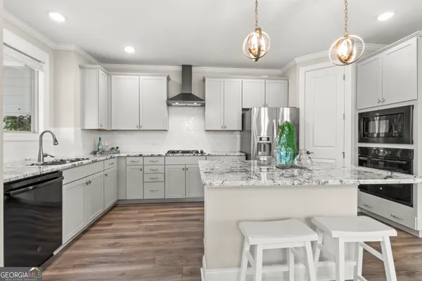 a large kitchen with kitchen island granite countertop lots of counter top space and stainless steel appliances