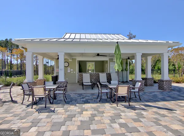a view of a chairs and table in patio with a barbeque
