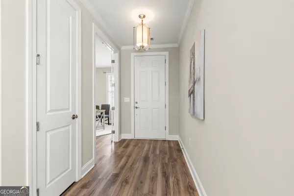 a view of a hallway with wooden floor and staircase