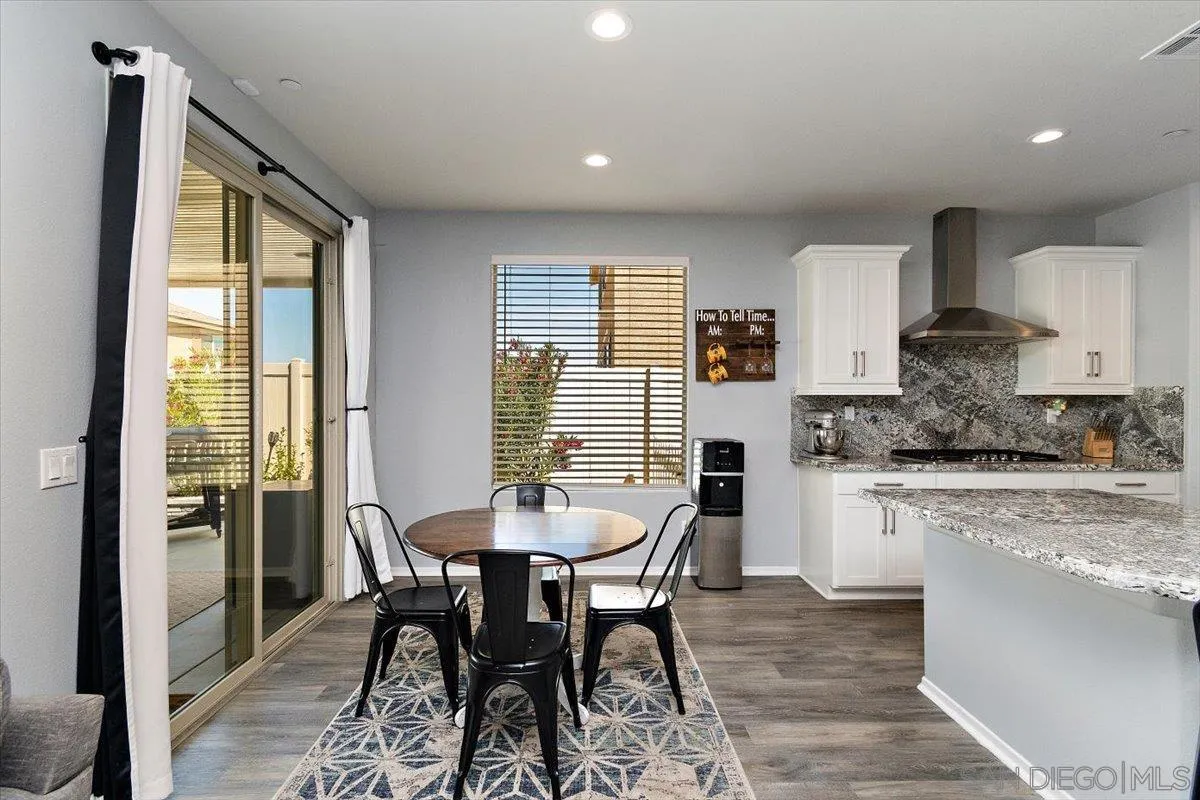 29564 Rigging Way Menifee, CA 92584 - Photo 6 of 30 a kitchen with granite countertop kitchen island stainless steel appliances a table and chairs in it