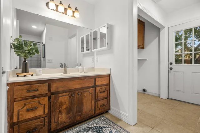 a spacious bathroom with a double vanity sink a mirror and a shower