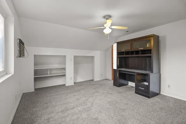a view of an empty room with a fireplace and cabinet