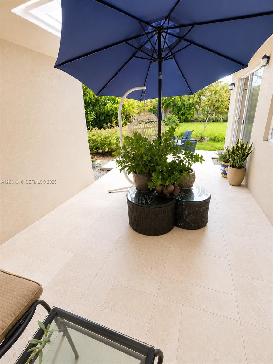14856 Southwest 179th Street Miami, FL 33187 - Photo 32 of 33 a view of a patio with a table and chairs under an umbrella