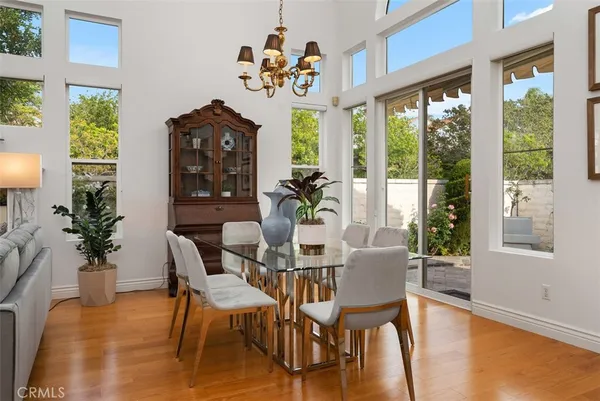 a dining room with furniture wooden floor a potted plant and a chandelier