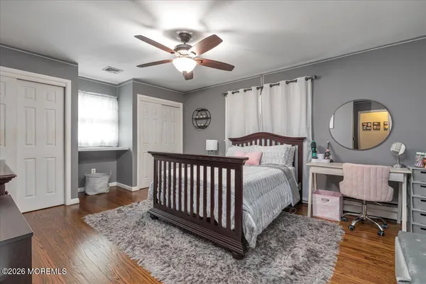 a bedroom with a large bed and wooden floor