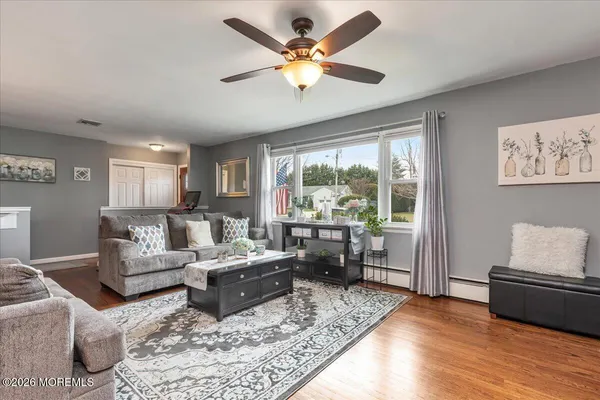 a living room with furniture wooden floor and a large window