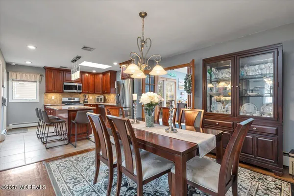 a view of a dining room and livingroom with furniture wooden floor a chandelier