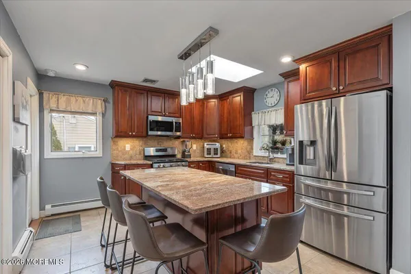 a kitchen with stainless steel appliances granite countertop a kitchen island a stove a table and chairs in it