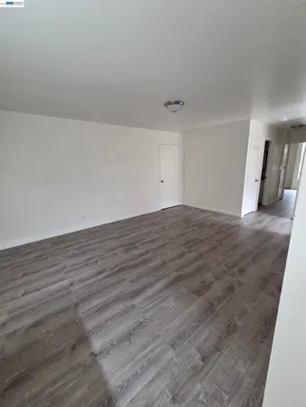 a kitchen with granite countertop a refrigerator a sink dishwasher and wooden cabinets with wooden floor