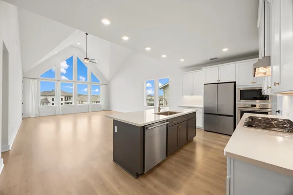 a kitchen with stainless steel appliances granite countertop a stove top oven a refrigerator a sink and a stove