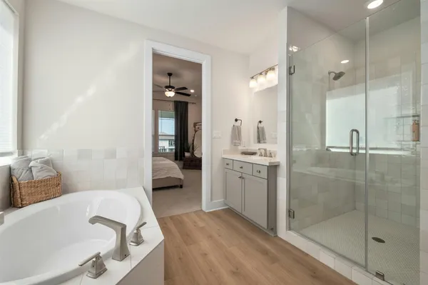 a bathroom with a double vanity sink a mirror and bathtub