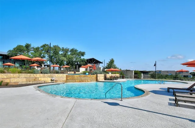 a view of a swimming pool with a yard and sitting area