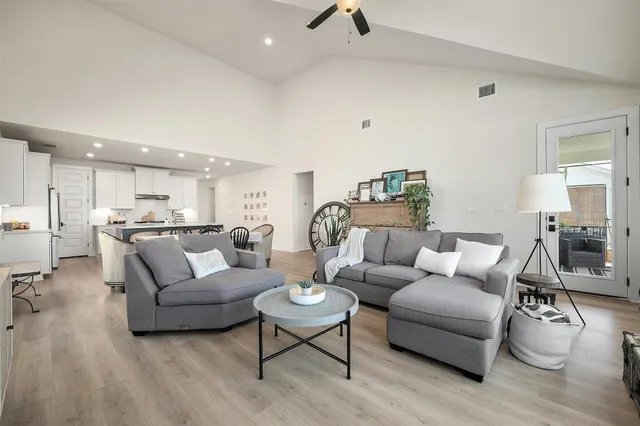a living room with furniture and a view of kitchen