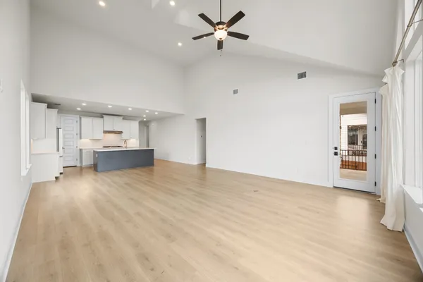a kitchen with kitchen island a sink a counter top space and living room view