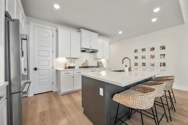 a kitchen with white cabinets and stainless steel appliances