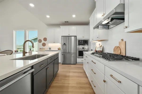 a kitchen with kitchen island white cabinets and stainless steel appliances