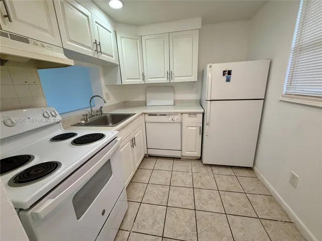a kitchen with a white stove top oven and white cabinets