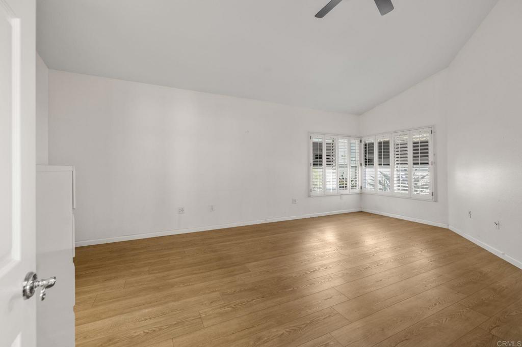 4939 Tilos Way Oceanside, CA 92056 - Photo 22 of 49 a view of an empty room with wooden floor and a window