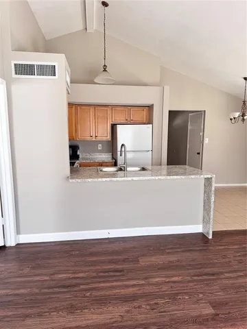 a view of a kitchen with wooden floor and a sink