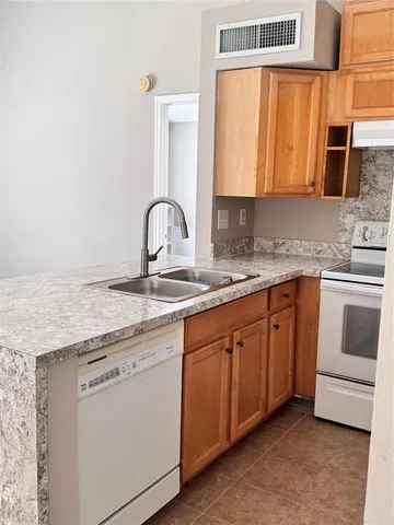a kitchen with granite countertop a sink stainless steel appliances and cabinets