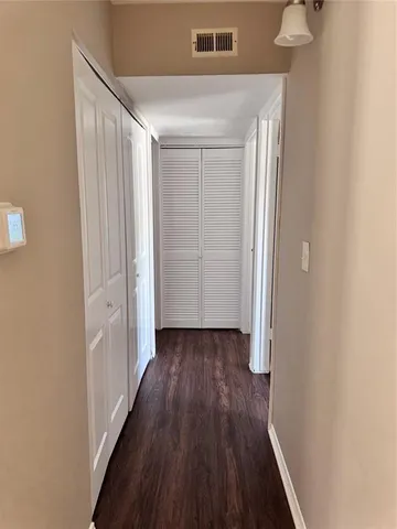a view of a hallway with wooden floor