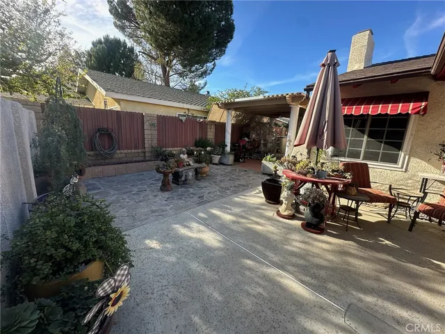 a view of a patio with table and chairs and potted plants
